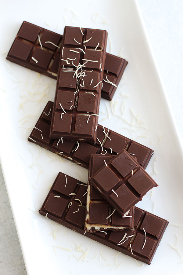 Stacked chocolate bars filled with pistachio pudding and kataifi, topped with shredded phyllo